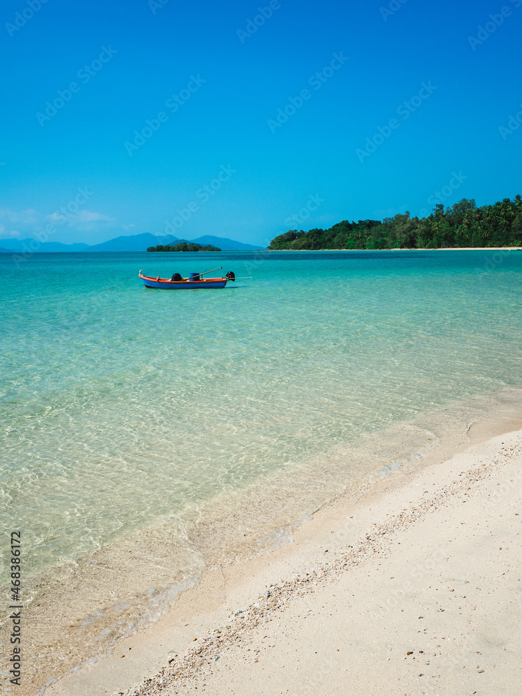 Obraz premium Peaceful white sand beach tropical island with crystal clear turquoise water and local fishing boat. Koh Mak Island, Trat Province, Thailand.