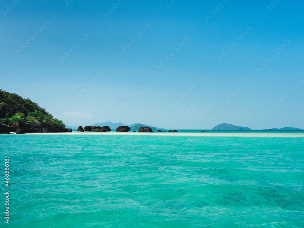 Stunning white sand bar with iconic black volcanic rock of Koh Kham Island and crystal clear turquoise water. Near Koh Mak Island, Trat Province, Thailand.