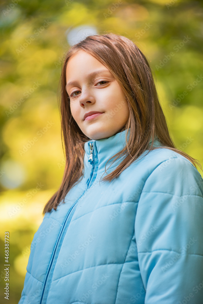 Portrait of girl in the forest smiling to the camera. A girl with long hair in autumn forest