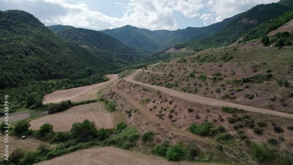 A quick start road in mountain scenery. Highway across the bridge between the hills. A quick start road in mountain scenery. Highway across the bridge between the hills.