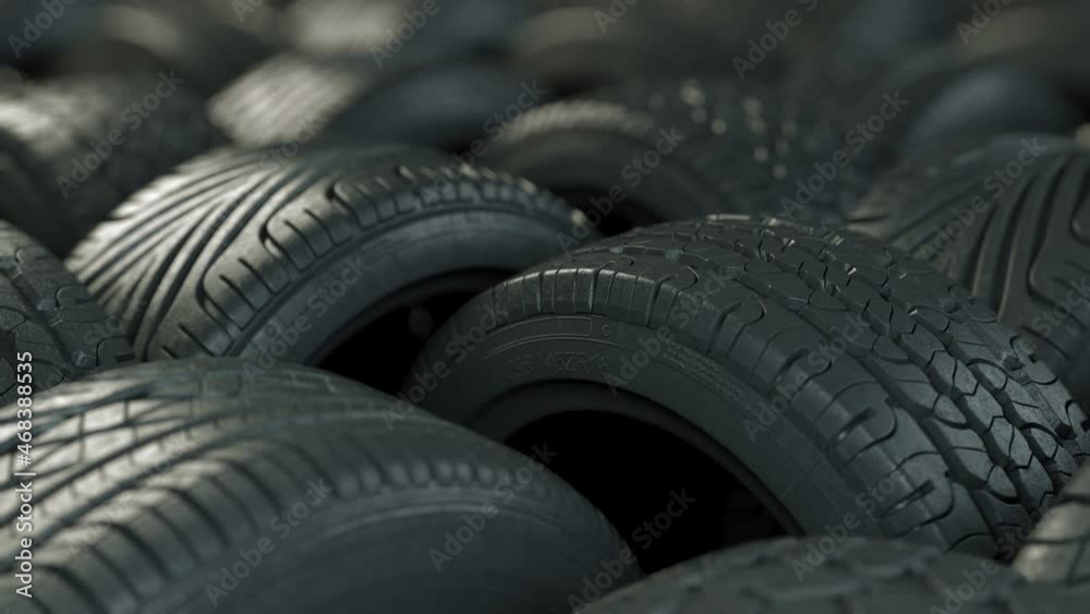 Car tires in elegant studio lighting. The film is looped, arranged in an interesting way in a warehouse or store, the background of the car industry. Car tires in elegant studio lighting. The film is looped, arranged in an interesting way in a warehouse or store, the background of the car industry.