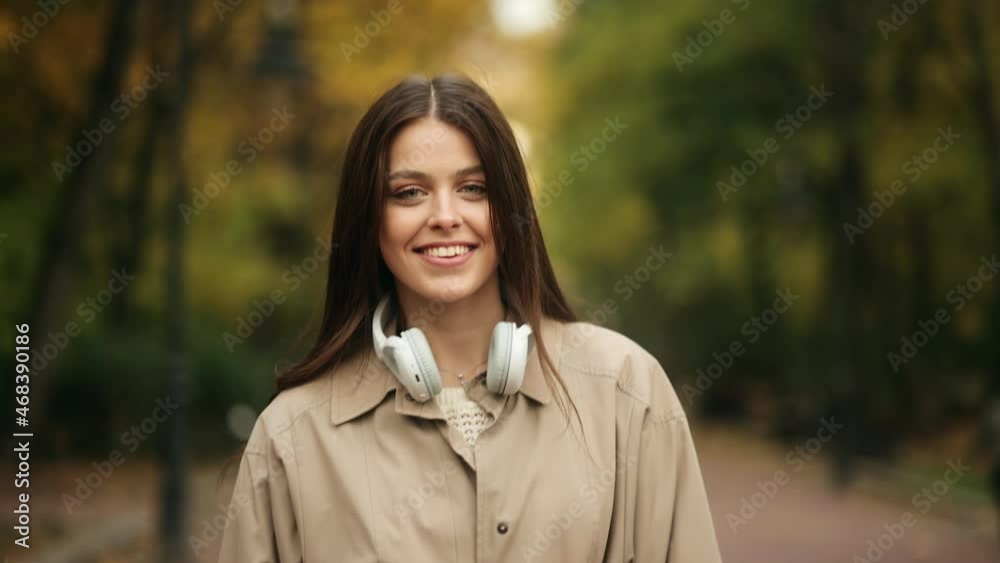 Portrait of an attractive brunette woman walking in the park at fall on a sunny day and smiling Portrait of an attractive brunette woman walking in the park at fall on a sunny day and smiling