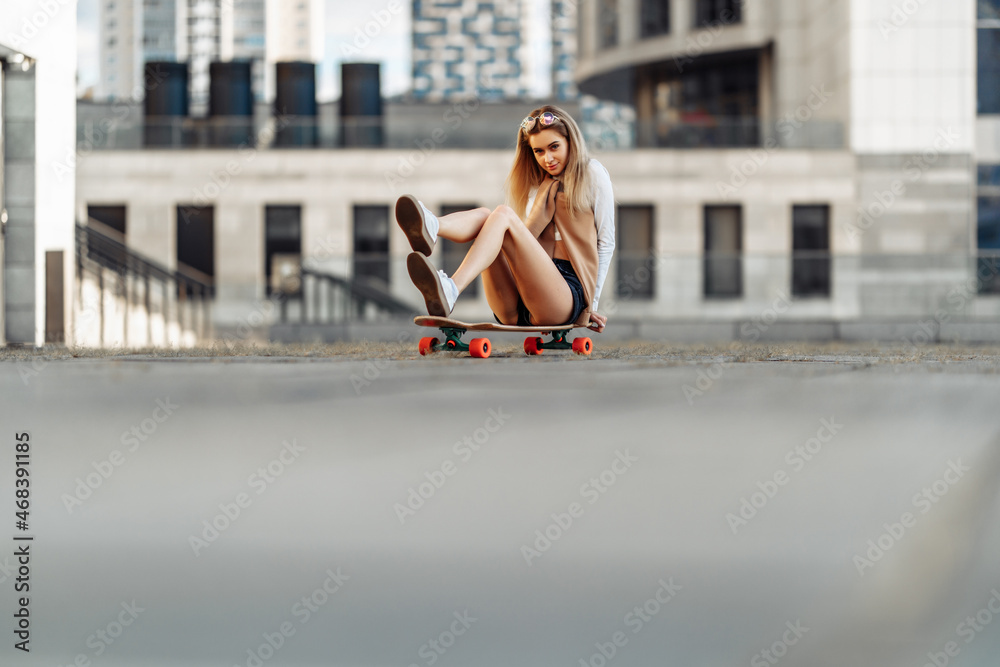 Young woman rides a longboard.