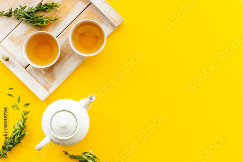 Two cups of tea with white teapot, top view