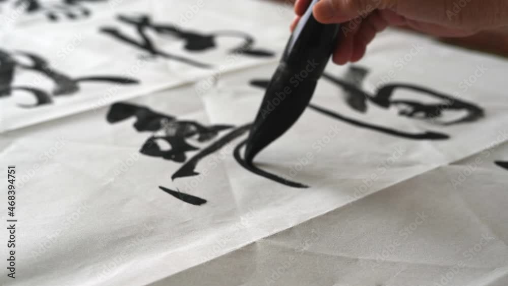 An old calligrapher is writing calligraphy and writing calligraphy