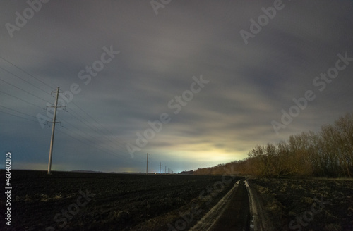 railroad tracks in the morning forest in the night . Night landscape. Nightsky and clouds . Stars in the sky . Lights of the city . Evening forest . Landscapes of Ukraine . Night and morning time 