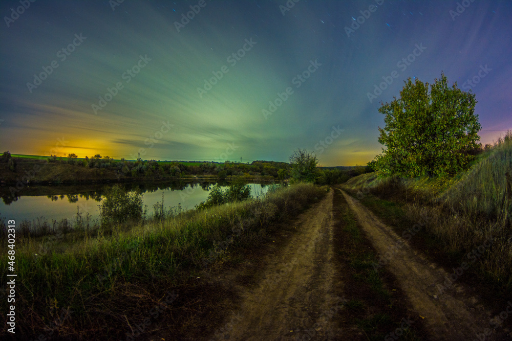 road and tree  forest in the night . Night landscape. Nightsky and clouds . Stars in the sky . Lights of the city . Morning forest . Evening forest  . Landscapes of Ukraine . Night and morning time 