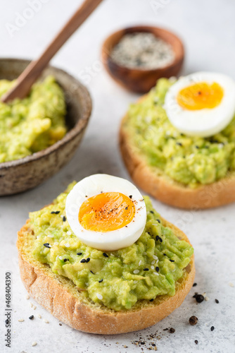 Toast with mashed avocado and egg garnished with sesame seeds, closeup view. Healthy breakfast or snack meal