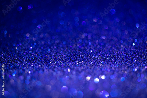 Blue glitter lights. Shiny sparkles, bokeh effects, glowing surface. Selective focus, christmas abstract background