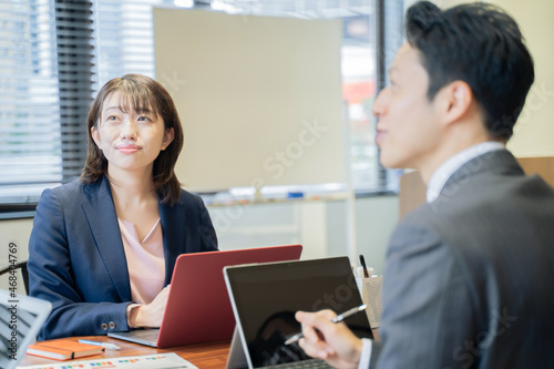 ノートパソコンで会議をする2人の男女のビジネスマン