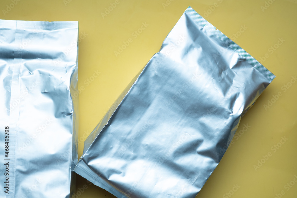 Foil bags on yellow background.
