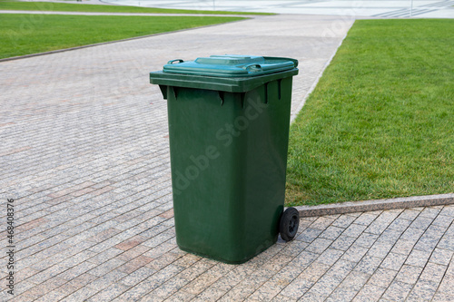Foto Plastic green garbage can for collecting garbage in the park