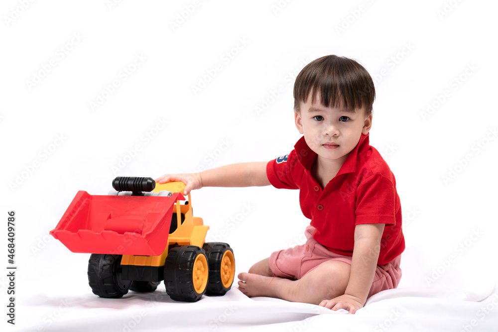 cute little boy sitting and playing toy excavator on white background. happy children playing toys cute little boy sitting and playing toy excavator on white background. happy children playing toys