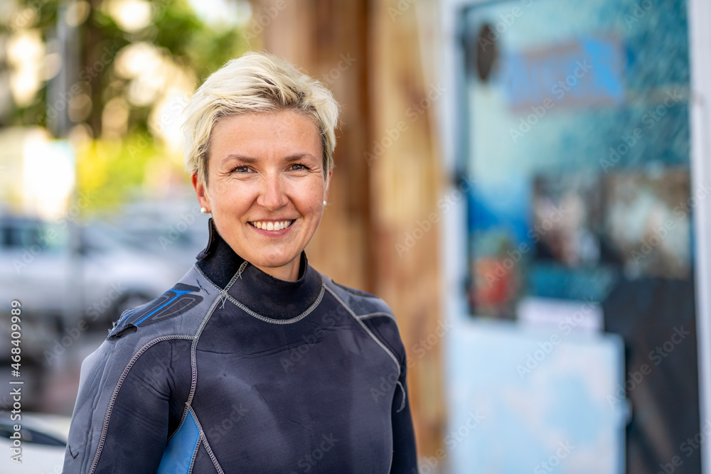 Portrait of a happy scuba diver woman in a wet suit. - obrazy, fototapety, plakaty 