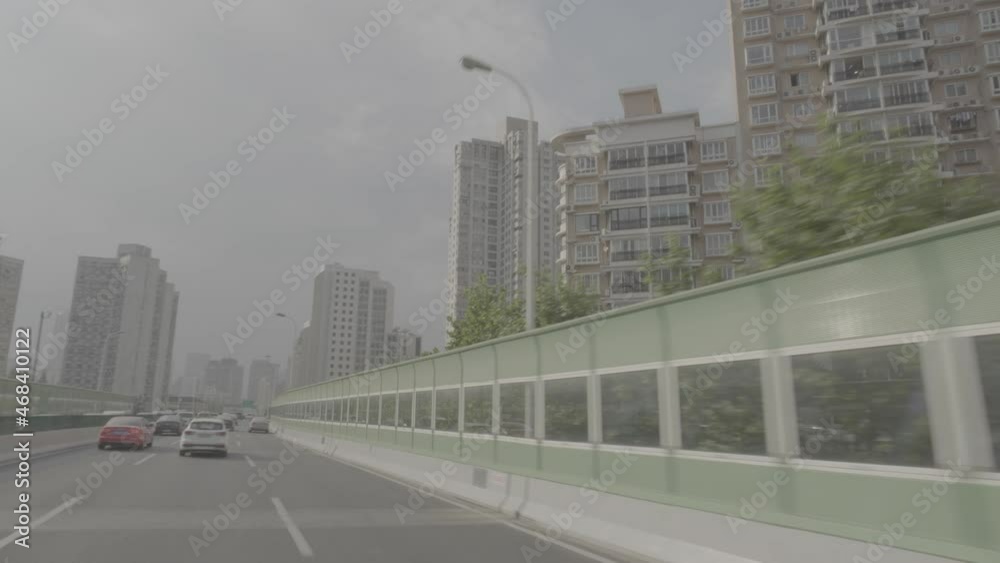 Traveling by car in a Shanghai highway between residential and modern office buildings Traveling by car in a Shanghai highway between residential and modern office buildings