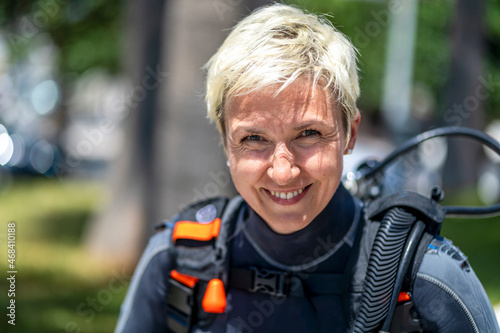 Portrait of a happy scuba diver with an oxygen tank and wet suit already on © malajscy