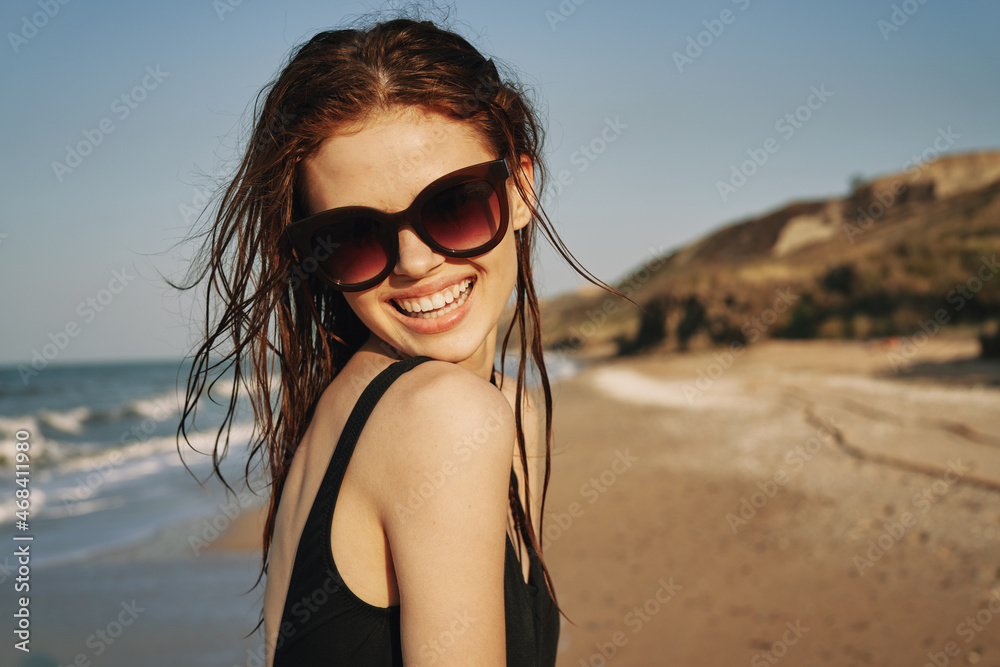 pretty woman in black swimsuit posing tanning tropics