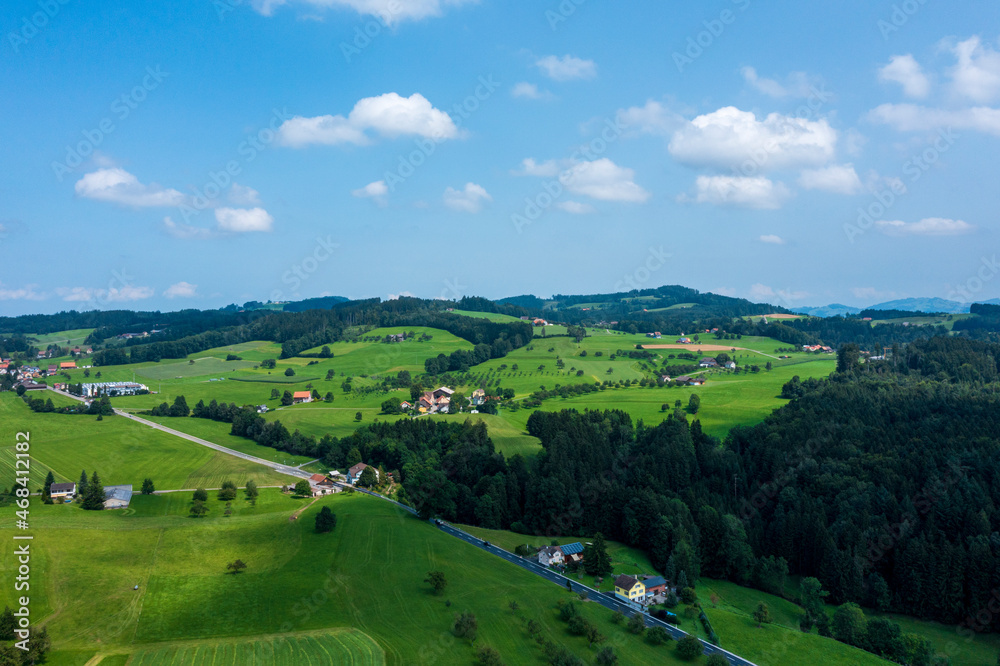 Panorama aerial view of the green Swiss hills on a summers day with blue skies.