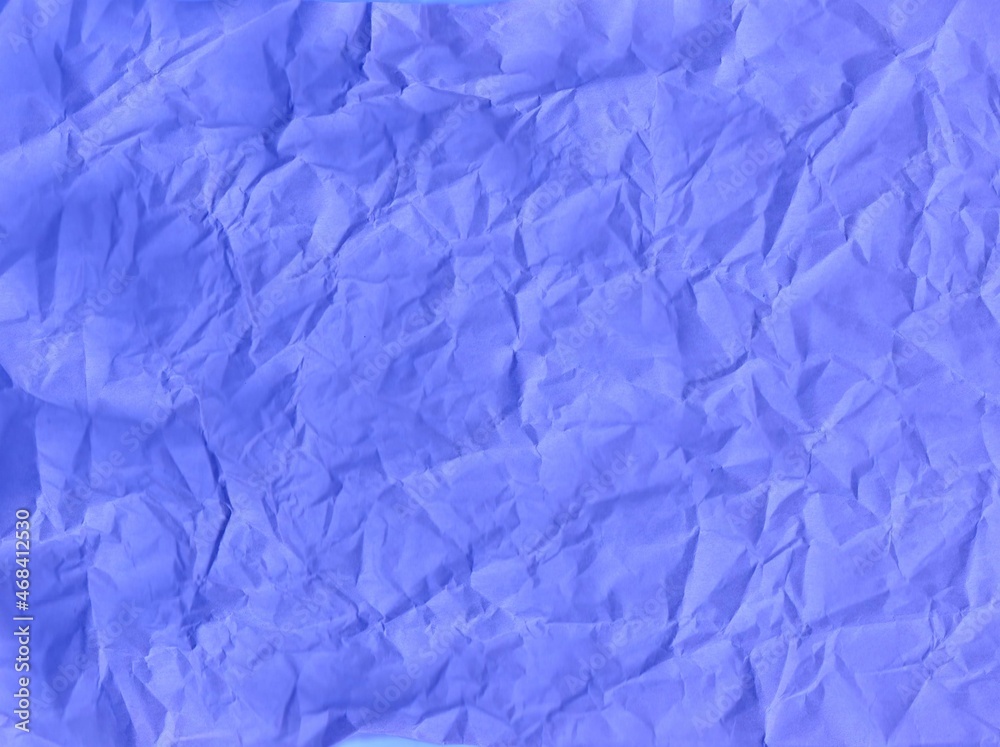 Obraz premium Crumpled blue wrapping paper with a solid background.