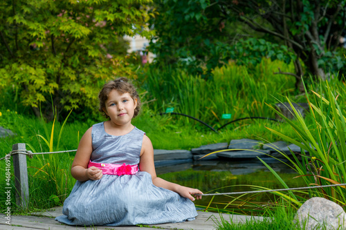 Fototapeta Naklejka Na Ścianę i Meble -  little girl sitting on the grass