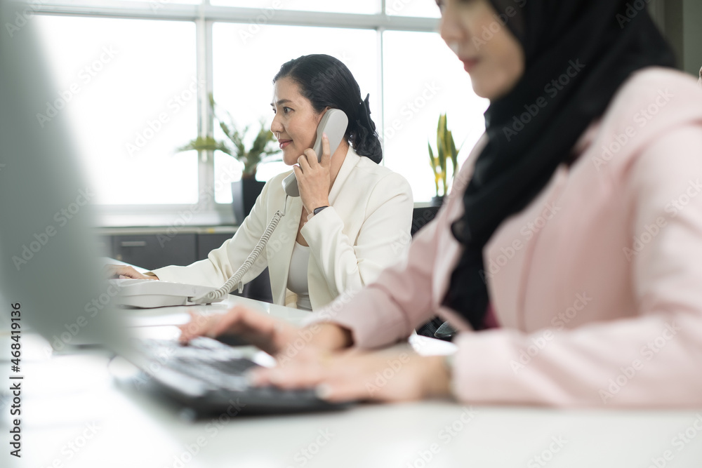 Asian businesswoman call service to customer. Professional team consult contact and talking with business partners in office. Asian businesswoman call service to customer. Professional team consult contact and talking with business partners in office.