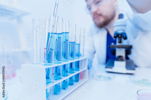 Laboratory research and testing of new COVID vaccines. Portrait of Scientist hold the pipette and drop the chemical liquid for research and analysis in a laboratory.