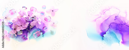 Creative image of pink and purple Hydrangea flowers on artistic ink background. Top view with copy space