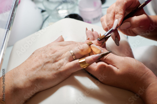Professional manicurist fixes and beautifies a client s nails