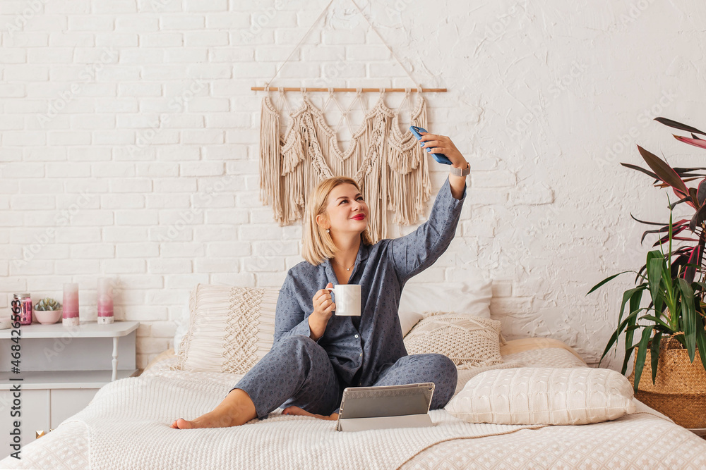 Beautiful young woman in pajamas, working on a laptop in bed, talking on  the phone. Online shopping Stock Photo | Adobe Stock