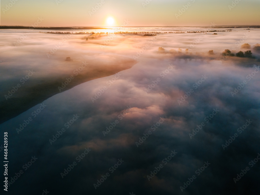 A magical dawn. Autumn fog covers fields and lakes. Long shadows from the trees. Photo from the drone. High quality photo