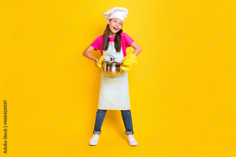 Photo of funny crazy little girl hold pot wear gloves white apron headwear isolated yellow color background Photo of funny crazy little girl hold pot wear gloves white apron headwear isolated yellow color background