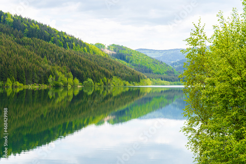 Scenic panoramic view of classic mountains with idyllic lake. Picturesque landscape of green mountains and lake