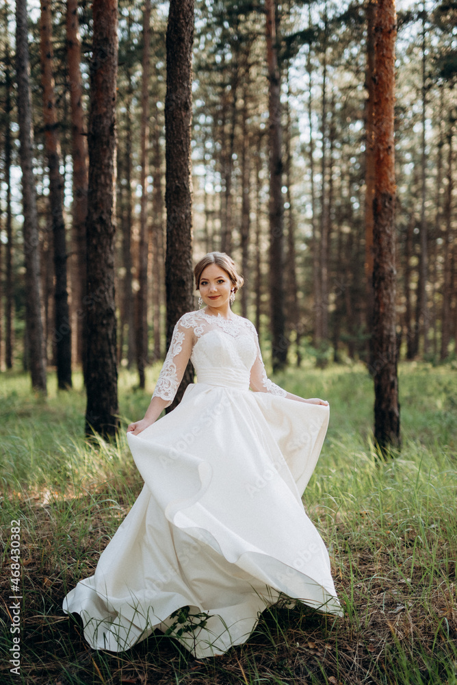 the bride walking in a pine forest