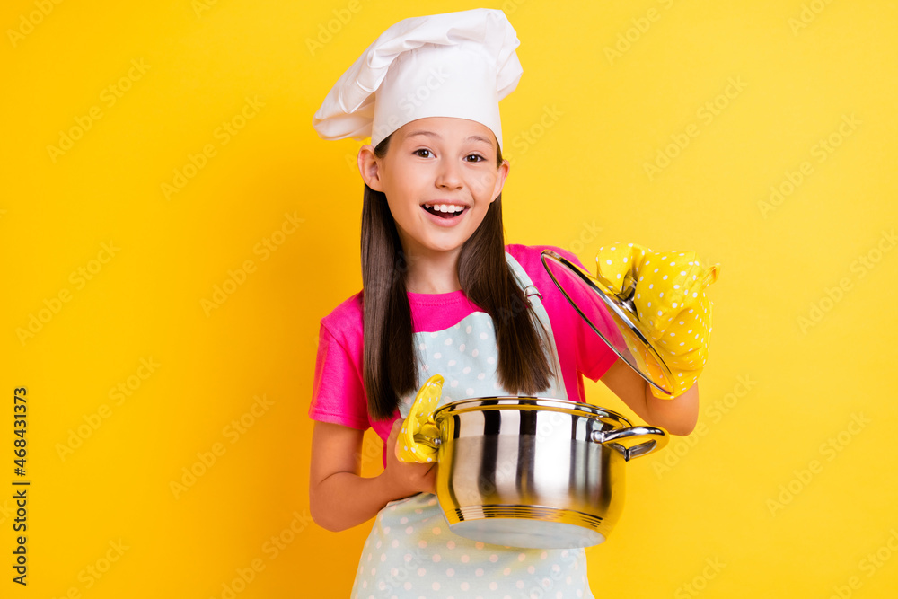 Photo of excited chef girl open saucepan check meal ready wear white apron hat isolated yellow color background Photo of excited chef girl open saucepan check meal ready wear white apron hat isolated yellow color background