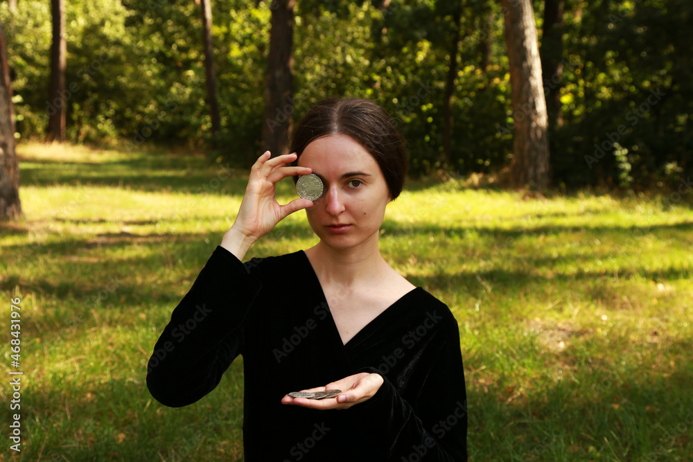 Woman in black dress holding medieval silver coin Woman in black dress holding medieval silver coin