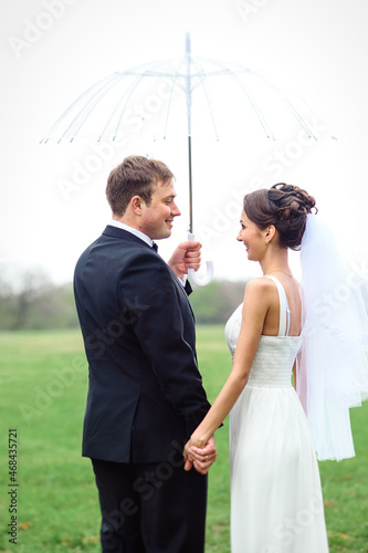 Photo bride and groom on a rainy wedding day walking