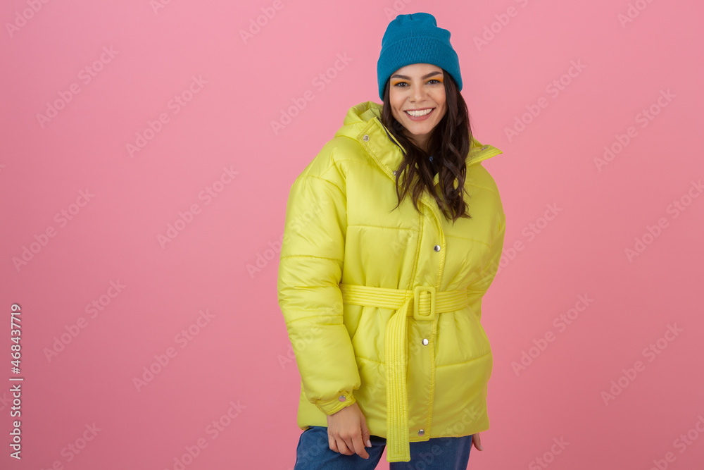 attractive active woman posing on pink background in colorful winter down jacket of bright ryellow color, smiling fun, warm coat fashion trend, crazy shocked surprised face expression