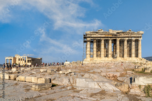 Parthenon temple and the Erechtheion temple (or Erechtheum) with the figures of Caryatids at the archaeological site of Acropolis . Sunny day, cloudy blue sky