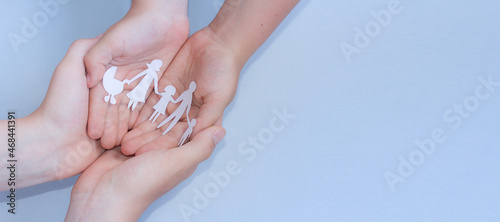close up of womans cupped hands showing paper man family. banner