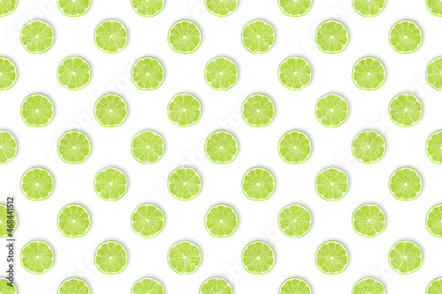 Green vitamin bomb for bars and kitchens: Pattern of freshly cut lime slices against white background. Healthy fruit concept, table top view, flat lay.