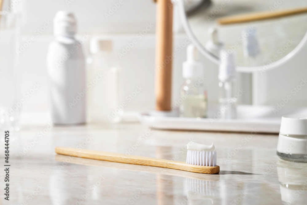 Eco-friendly bamboo toothbrush with toothpaste in the bathroom.