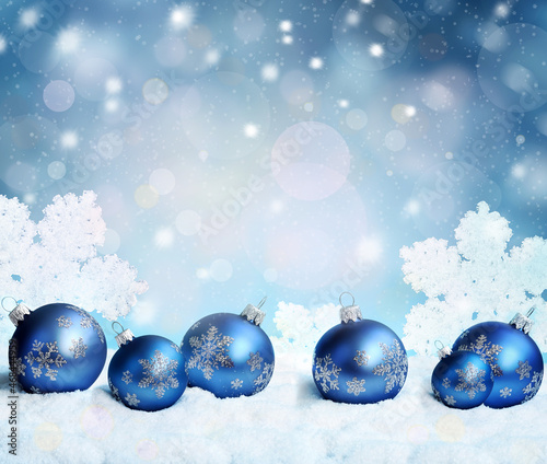Beautiful blue Christmas balls  snowflakes on snow on winter background.
