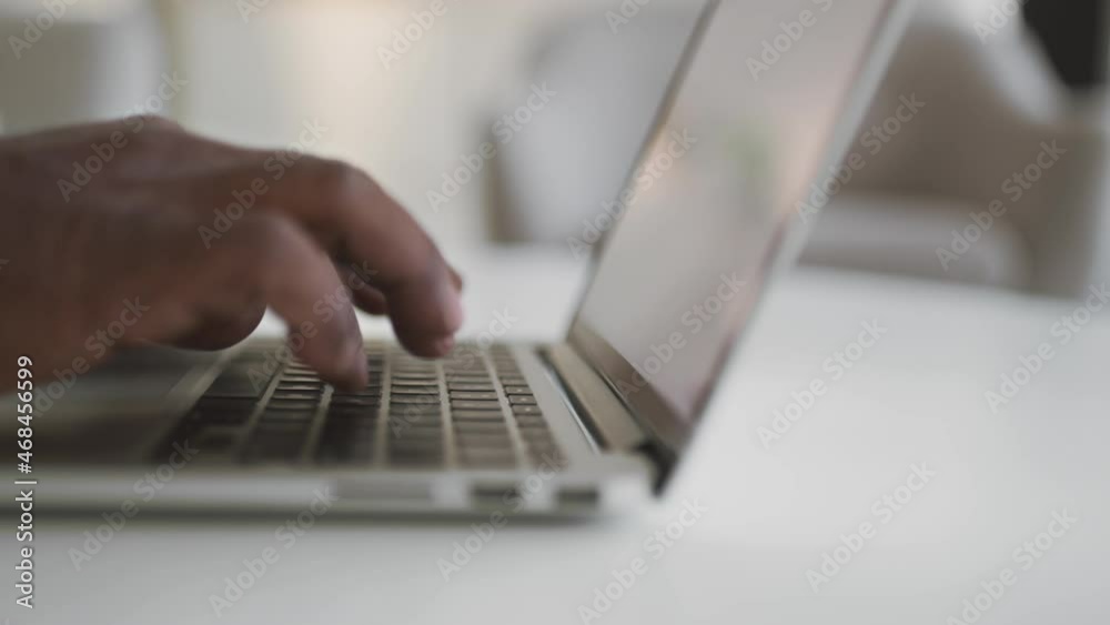 Unrecognizable african american senior man typing on laptop keyboard at home, black male hands working on computer