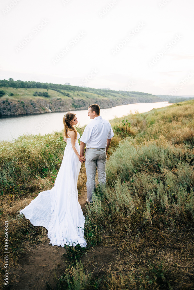young couple a girl and a guy are walking in the field young couple a girl and a guy are walking in the field