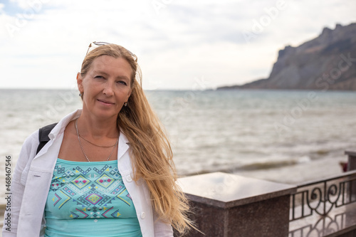 The blonde with long hair against the background of the sea and mountains. Travel and tourism © Natalia