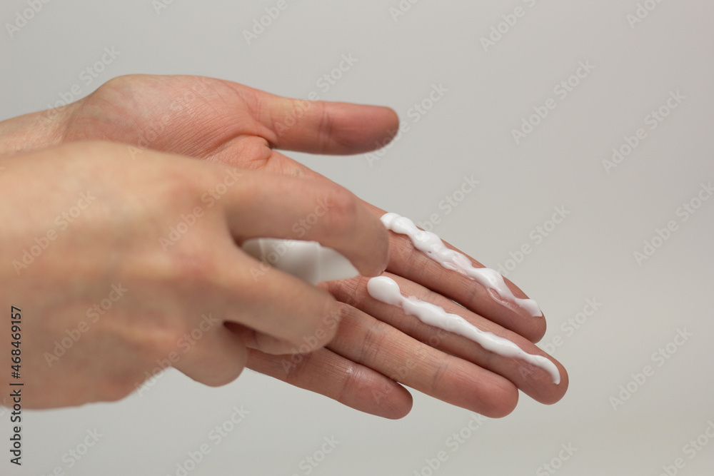 A person applying the correct amount of sunscreen for face and neck.