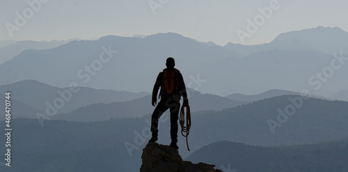 silhouette of mountaineer climbing the mountain