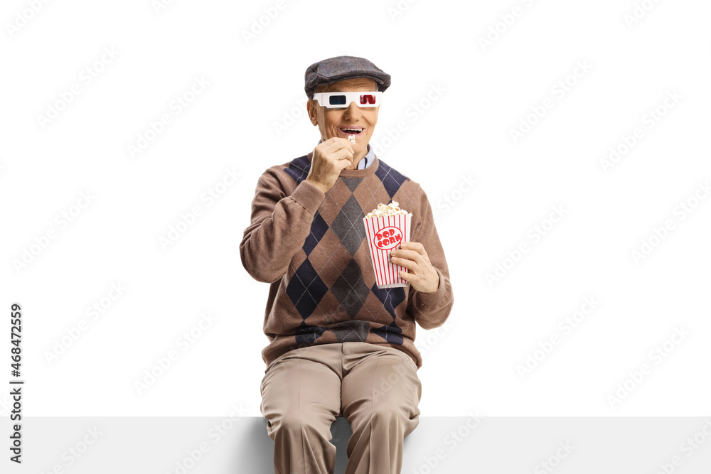 Elderly man sitting on a panel with popcorn and 3d movie glasses Elderly man sitting on a panel with popcorn and 3d movie glasses