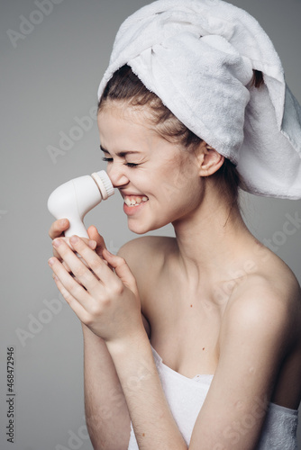 woman with towel on head facial massager skin care hygiene