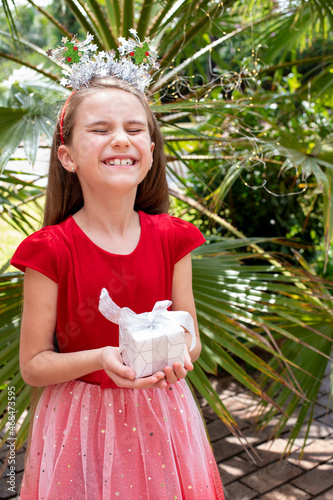 Litlle girl holds a gift in her hands and laughs